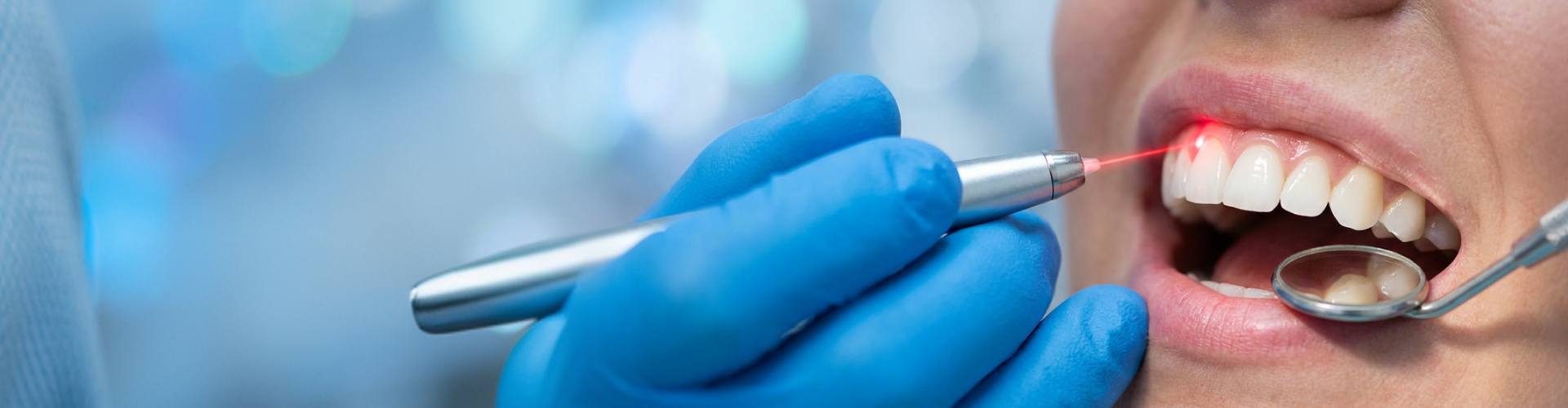 Dentist performing laser gum contouring surgery to reshape a patient’s gingival tissue line.